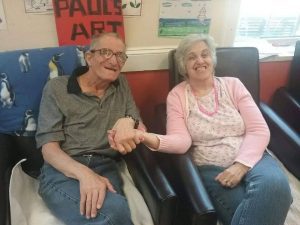 Two seniors with disabilities holding hands