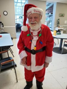 A senior man with disabilities smiling in his Santa costume